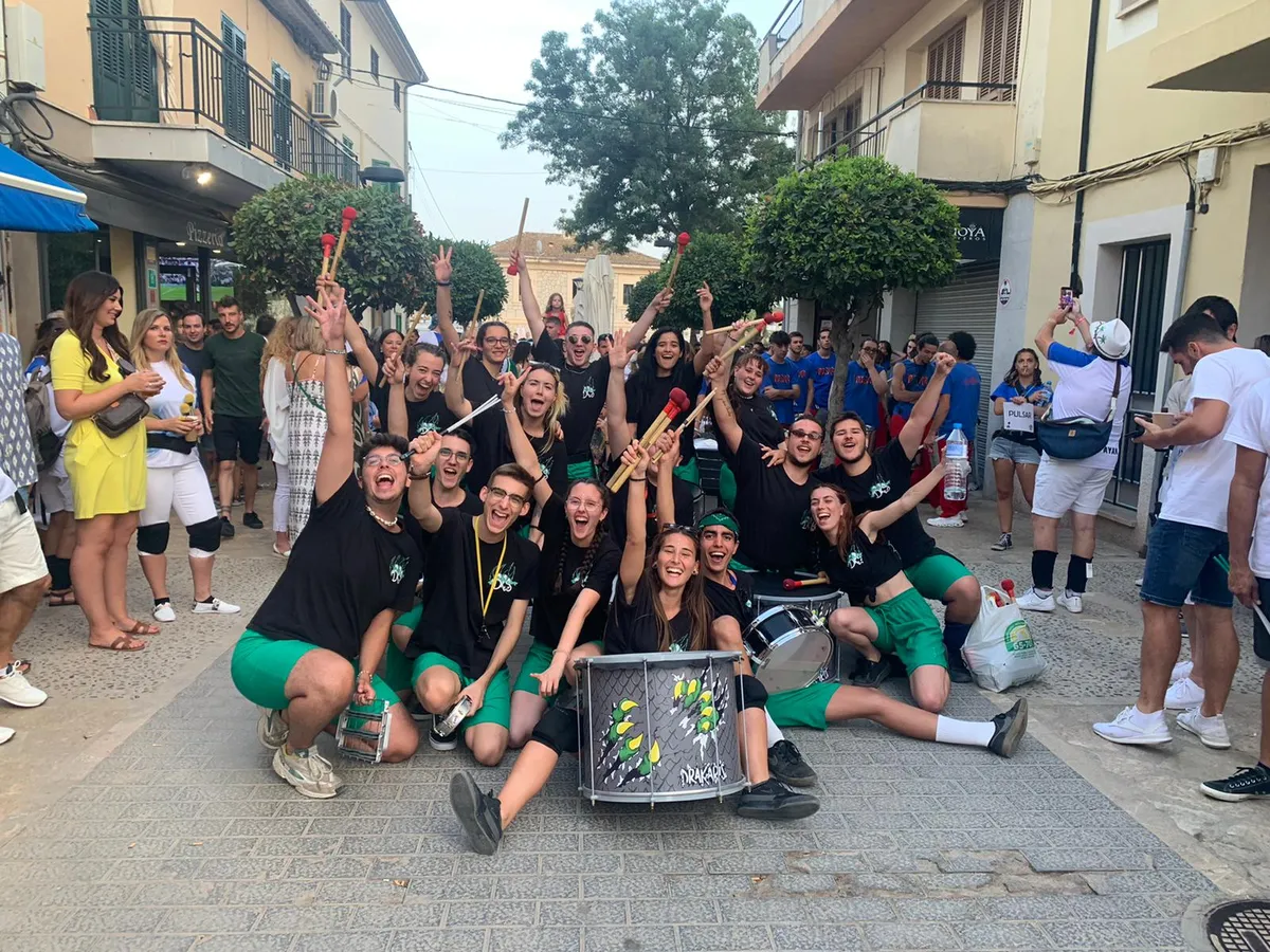 La colla celebrant al carrer, a Mallorca, amb les baquetes enlaire