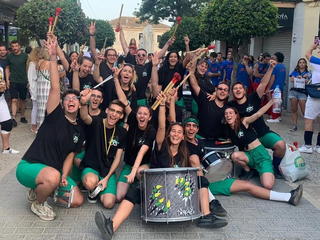 La colla celebrant al carrer, a Mallorca, amb les baquetes enlaire